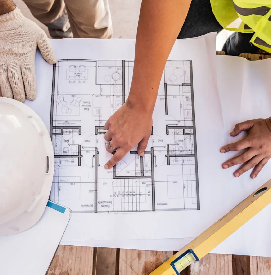 Architects reviewing building plans on table.